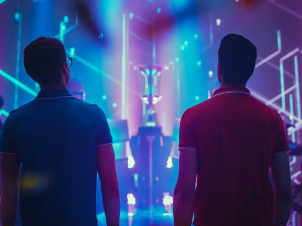 Two Professional eSports Gamers walking on Stage to Participate in the Cyber Games Championship Event. Competitive Online Live Streaming Tournament. Stylish Back View Shot